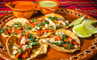 Deux tortillas et deux sauces d'accompagnement sont servies avec de la nourriture mexicaine sur une assiette.